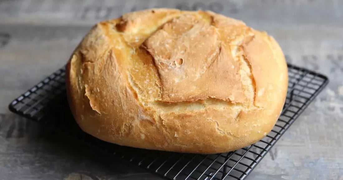 Pagnotta di pane fatto in casa dorata che raffredda su una griglia